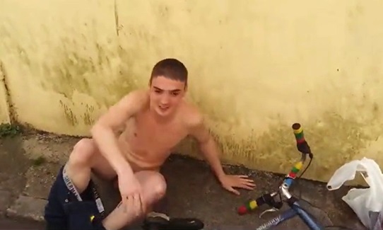 Naked boy with his bike on the street where he lives